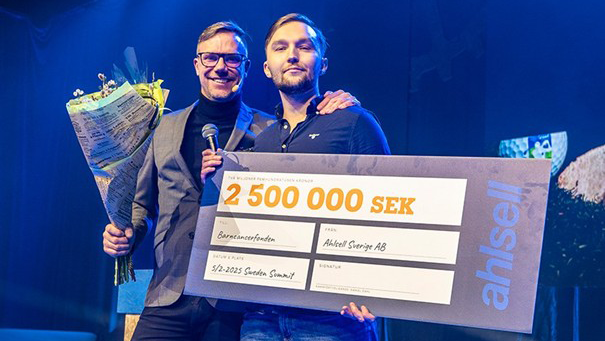 Ahlsell &ouml;verl&auml;mnar check till Barncancerfonden