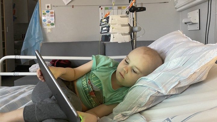 Karl ligger i en sjukhussäng och kollar på ipad.