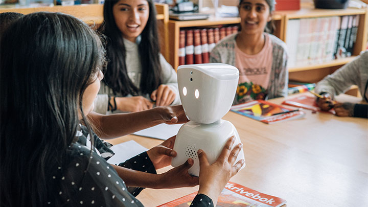 En flicka h&aring;ller i AV1-robot i skolan